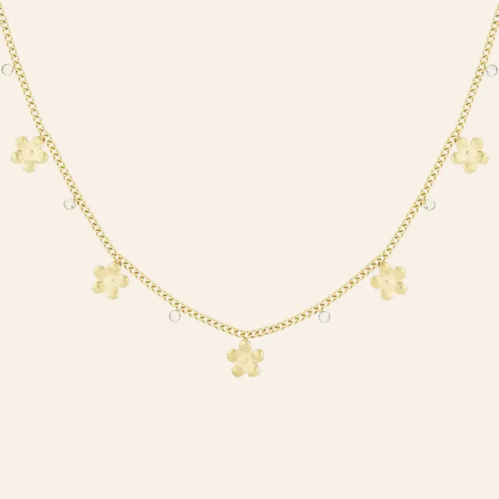 Collier Lima en acier inoxydable doré, délicates fleurs andines suspendues avec grâce et strass, présenté seul sur fond neutre.