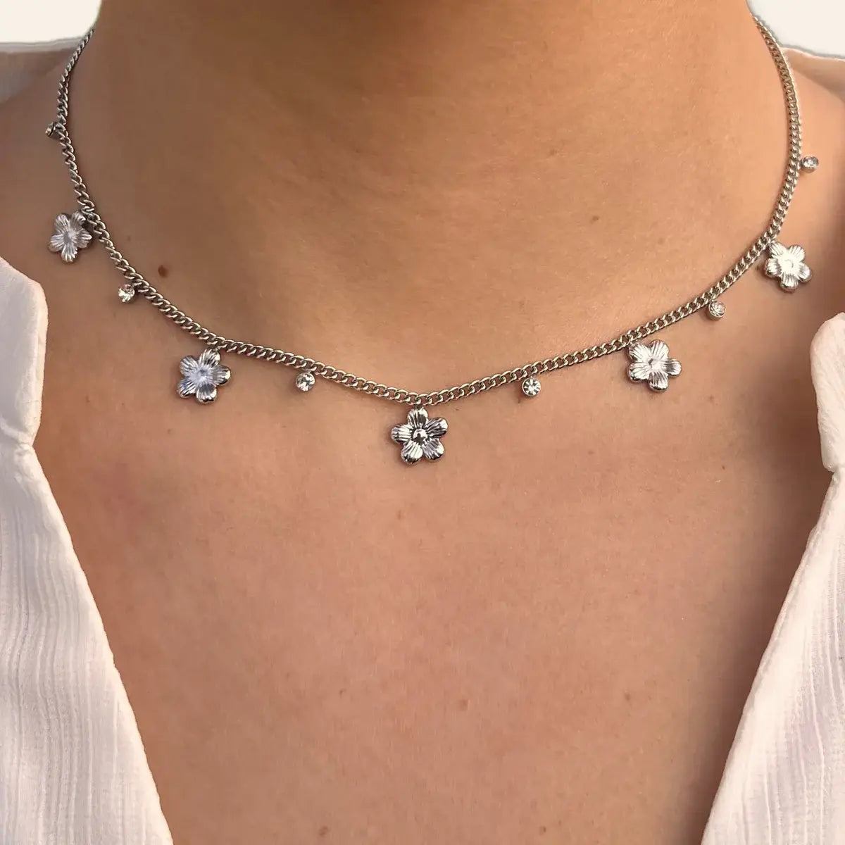 Collier Lima en acier inoxydable argenté porté, mettant en valeur les fleurs andines, les strass et leur design raffiné.
