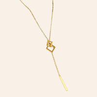 Collier Talinn en acier inoxydable doré, forme en Y avec deux carrés et un pendant fin, présenté seul sur fond neutre.