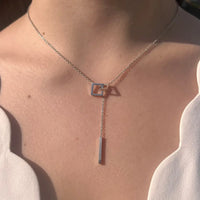 Collier Talinn en acier inoxydable argenté porté, design en Y raffiné avec carrés délicats et trait fin suspendu.