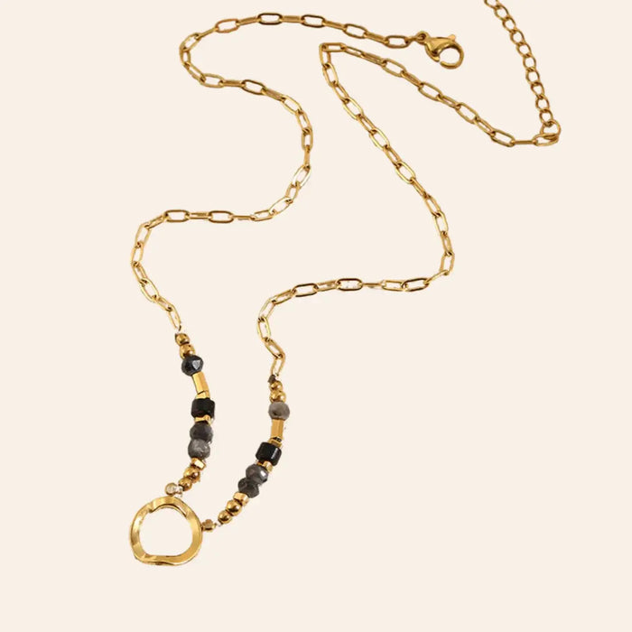 Collier Zanzibar en acier inoxydable doré avec perles et cercle central, ras de cou élégant présenté seul sur fond neutre.