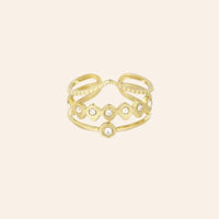 Bague Accra en acier inoxydable doré avec strass scintillants, design ajouré élégant.