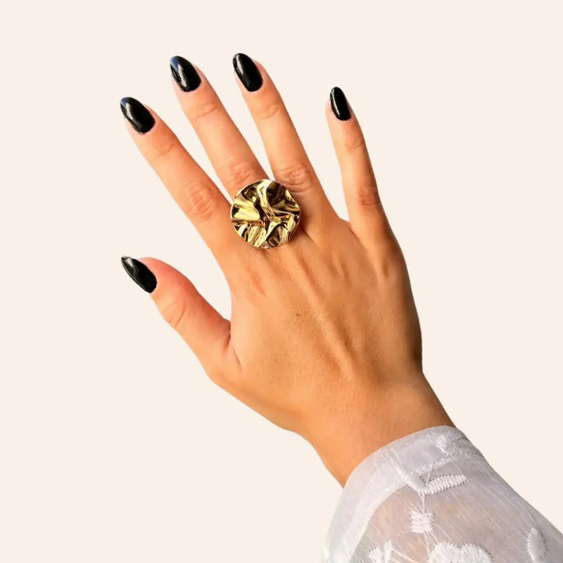 Bague Berlin dorée portée, forme ronde et courbes audacieuses, inspirée de l’architecture moderne de Berlin, ajoutant une touche contemporaine et sophistiquée à votre look.