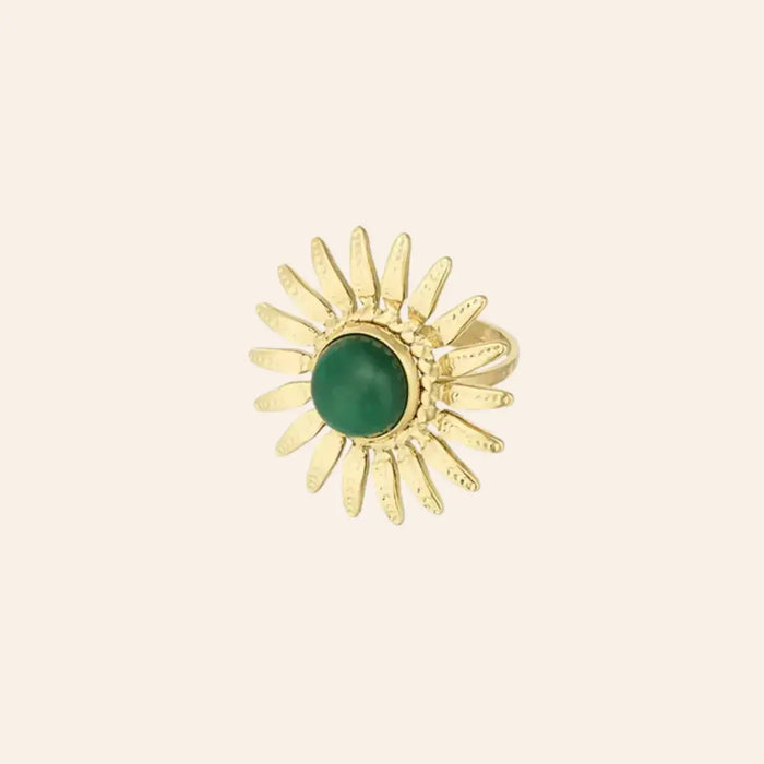 Bague Dakar en acier inoxydable doré, design solaire audacieux avec une pierre centrale en vert, entourée de rayons dorés, capturant l'énergie éclatante de Dakar, présentée seule sur fond neutre.