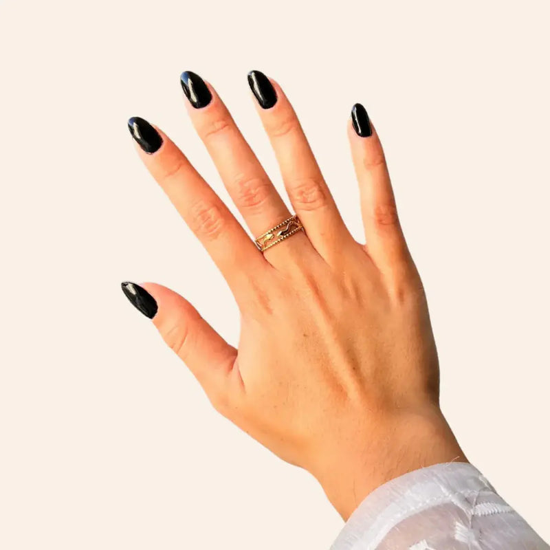 Bague Jakarta dorée portée, deux serpents entrelacés dans un design ajouré et fluide, capturant l'énergie dynamique de Jakarta, tout en ajoutant une touche de sophistication.