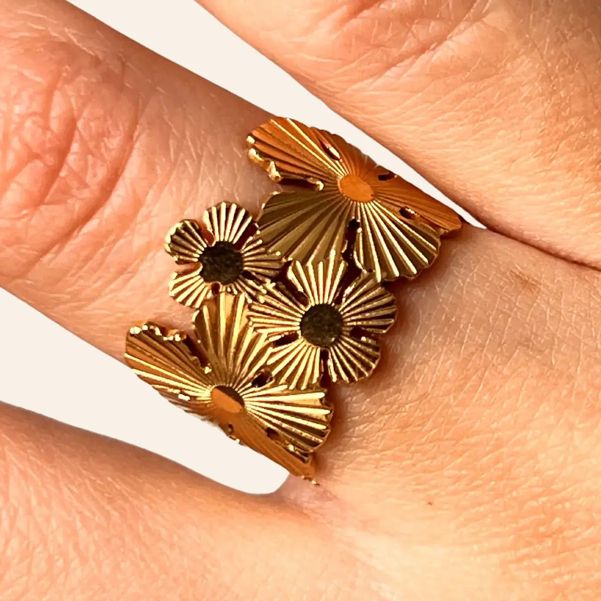 Zoom sur la bague Ottawa dorée en acier inoxydable, mettant en valeur les motifs floraux délicats et l’harmonie entre la nature et la modernité de l'architecture d'Ottawa.