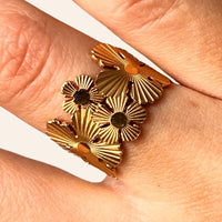 Zoom sur la bague Ottawa dorée en acier inoxydable, mettant en valeur les motifs floraux délicats et l’harmonie entre la nature et la modernité de l'architecture d'Ottawa.
