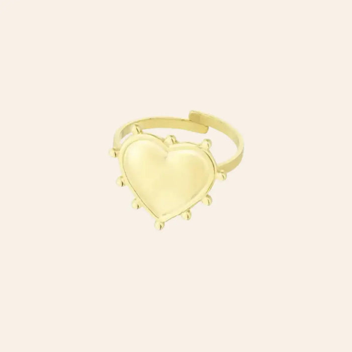 Bague Paris en acier inoxydable doré, cœur délicatement sculpté entouré de détails raffinés, capturant l’essence romantique et élégante de Paris, présentée seule sur fond neutre.