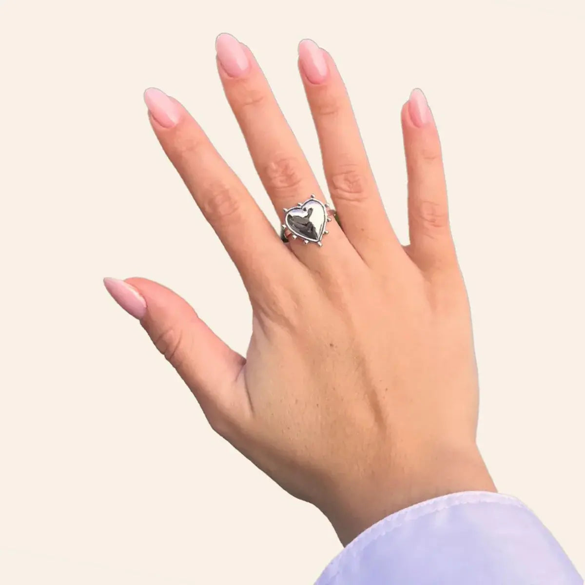 Bague Paris en acier inoxydable argenté portée, cœur sculpté et détails délicats qui ajoutent une touche d'élégance et de sophistication à votre look.