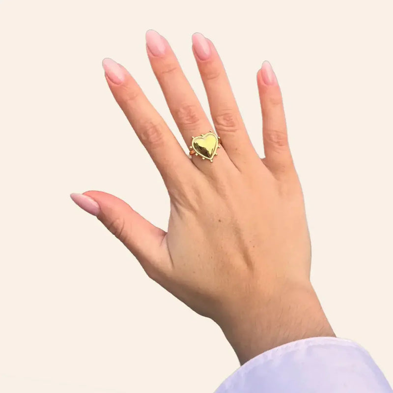 Bague Paris dorée portée, cœur finement sculpté et détails raffinés incarnant l’amour et la sophistication, parfaits pour symboliser l’élégance de Paris.