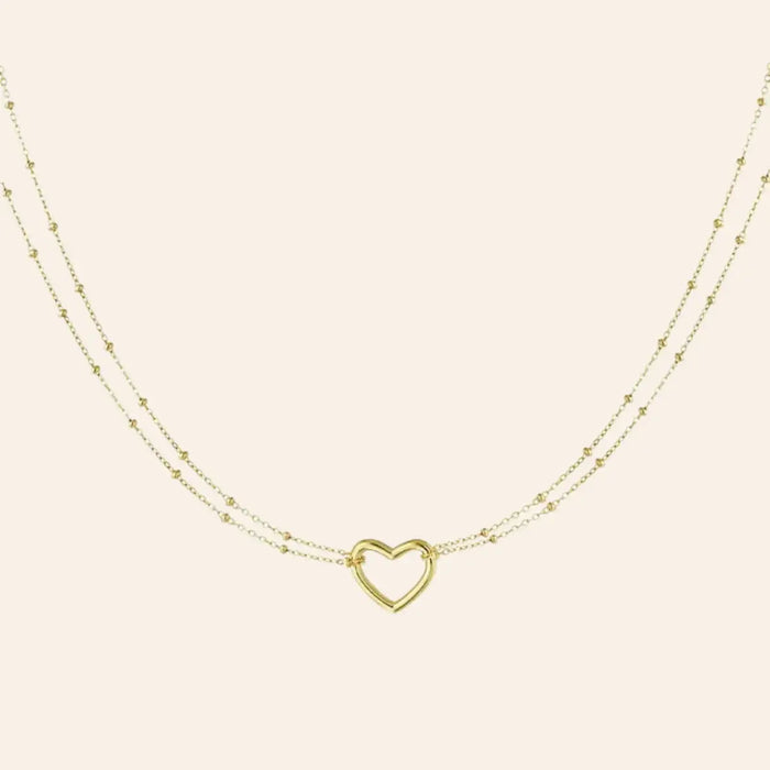 Collier Budapest en acier inoxydable doré, deux chaînes délicates ornées d'un cœur central, capturant l’essence romantique de Budapest, présenté seul sur fond neutre.