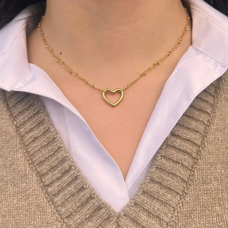 Collier Budapest doré porté, design élégant avec deux chaînes délicates et un cœur central, incarnant l’élégance discrète et la poésie de Budapest.
