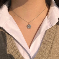 Collier Florence en acier inoxydable argenté porté, fleur raffinée suspendue au centre du collier, ajoutant une touche élégante à chaque mouvement.