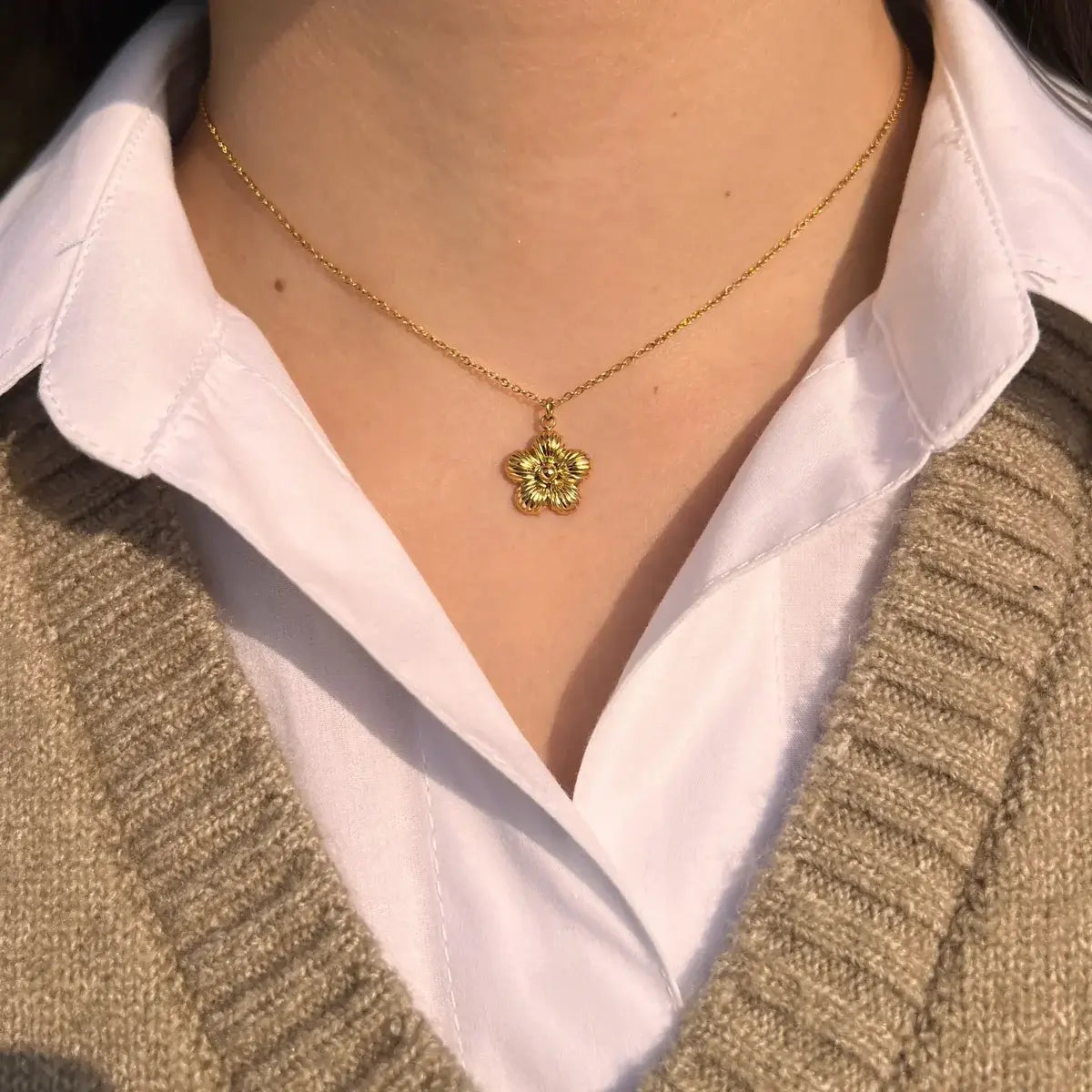 Collier Florence doré porté, fleur délicate apportant une touche de féminité et de raffinement à votre décolleté, ajoutant de la grâce à chaque mouvement.
