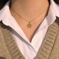 Collier Florence doré porté, fleur délicate apportant une touche de féminité et de raffinement à votre décolleté, ajoutant de la grâce à chaque mouvement.