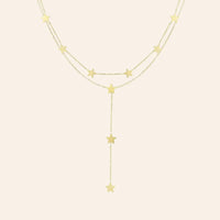 Collier Oslo en acier inoxydable doré, chaîne délicate avec étoiles suspendues en cascade, ajoutant une touche céleste et romantique, présenté seul sur fond neutre.