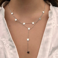 Collier Oslo en acier inoxydable argenté porté, design élégant et moderne avec des étoiles suspendues en cascade, apportant une touche céleste et raffinée à votre look.