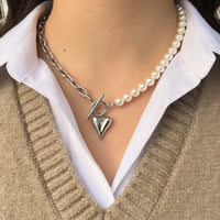 Collier Prague en acier inoxydable argenté porté, combinaison de perles et chaîne moderne, orné d'un charm cœur pour un style à la fois romantique et élégant.