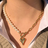 Collier Prague doré porté, design moitié chaîne et moitié perles avec charm cœur, ajoutant une touche romantique et sophistiquée à votre look.