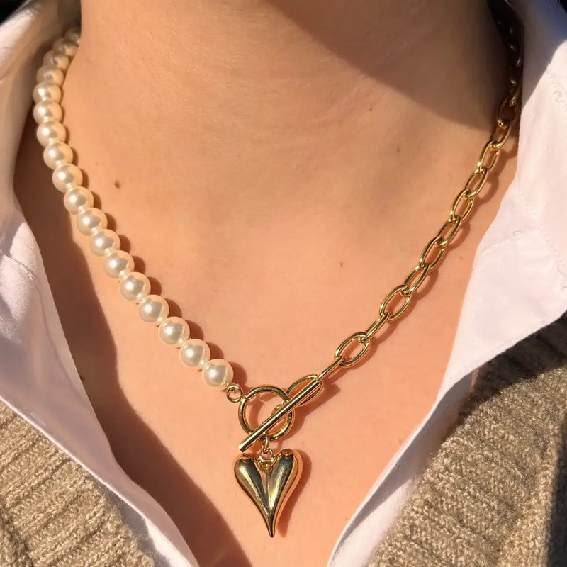 Collier Prague doré porté, design moitié chaîne et moitié perles avec charm cœur, ajoutant une touche romantique et sophistiquée à votre look.