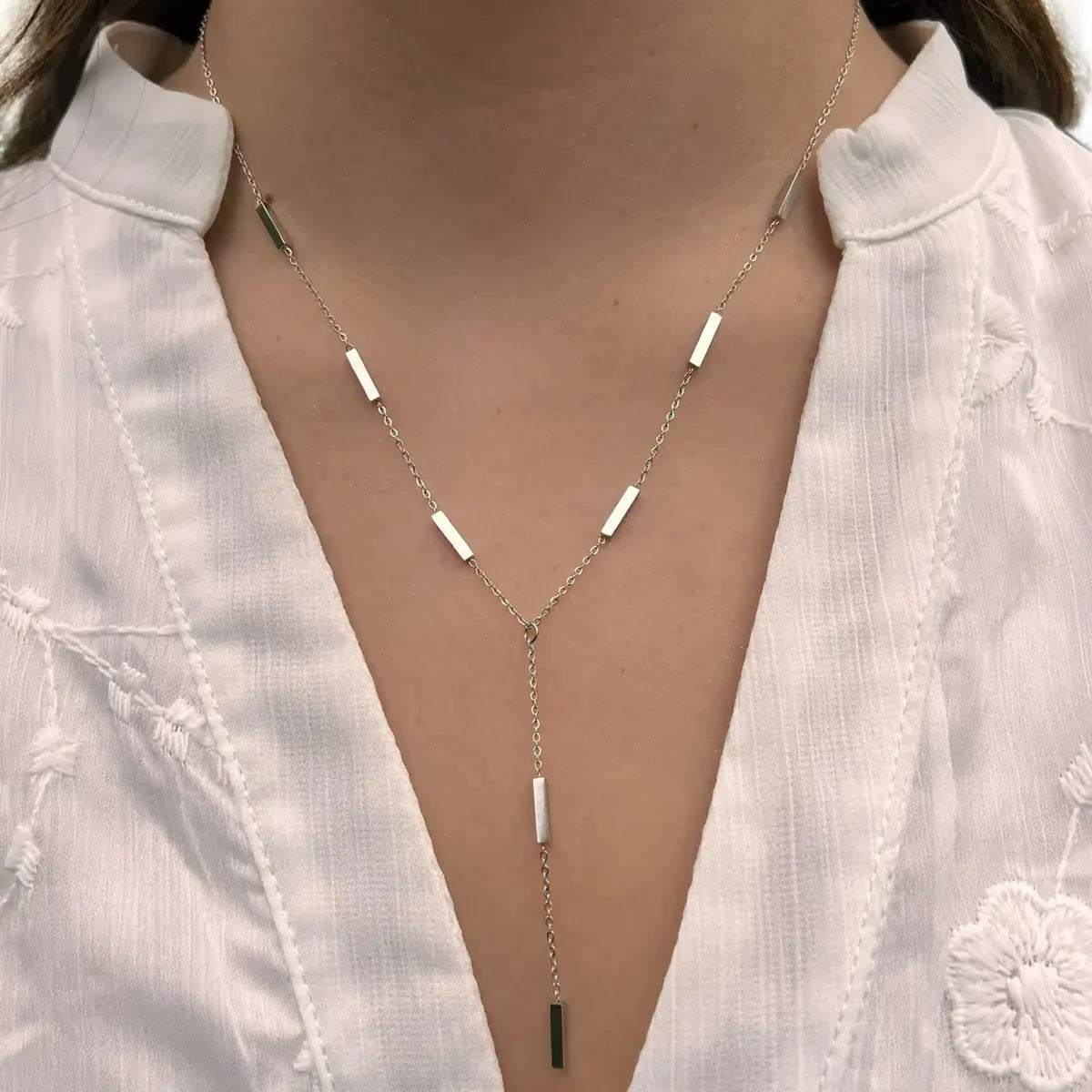 Collier Stockholm en acier inoxydable argenté porté, design épuré et géométrique avec des barres alignées, apportant une touche de sophistication discrète et moderne.
