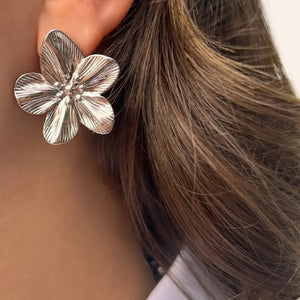 Boucles d’oreilles Athènes en acier inoxydable argenté portées, design floral symbolisant la sérénité et l’harmonie de l’architecture grecque.
