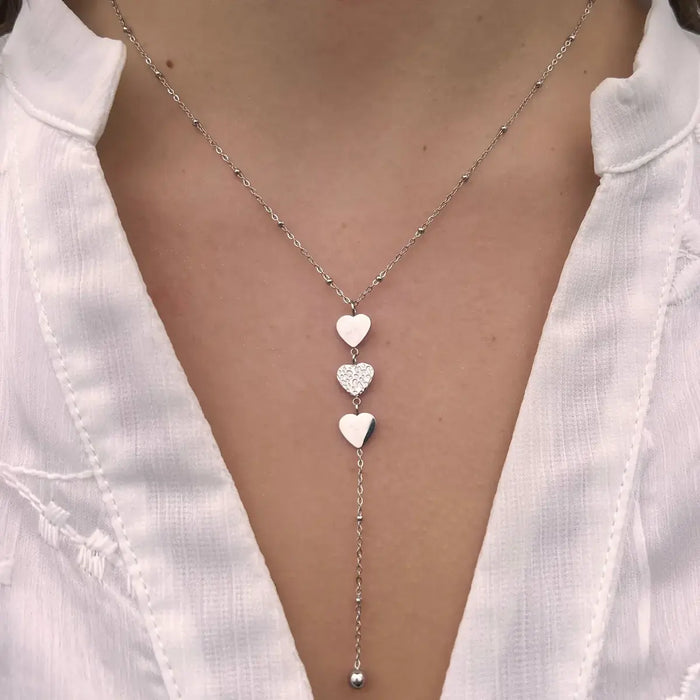 Collier Buenos Aires en acier inoxydable argenté porté, cœurs suspendus capturant l'intensité et la sophistication de Buenos Aires.