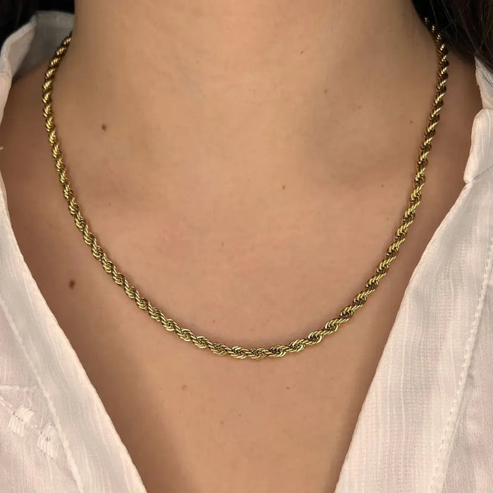 Collier Venise doré porté, chaîne torsadée délicate apportant une touche d'élégance discrète à un look minimaliste.