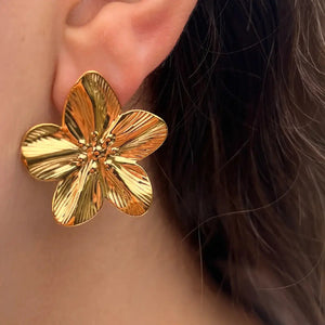 Boucles d’oreilles Athènes dorées portées, design floral majestueux évoquant la beauté intemporelle d'Athènes et les paysages méditerranéens.