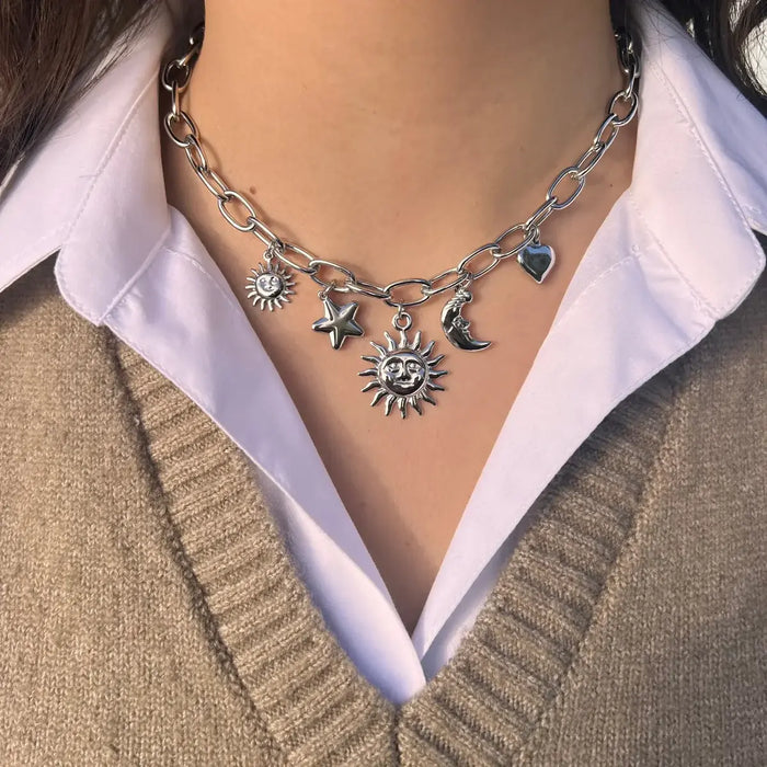Collier Madrid en acier inoxydable argenté porté, pendentifs soleils, étoile, lune et cœur suspendus, créant une aura de chaleur et de passion inspirée par Madrid.
