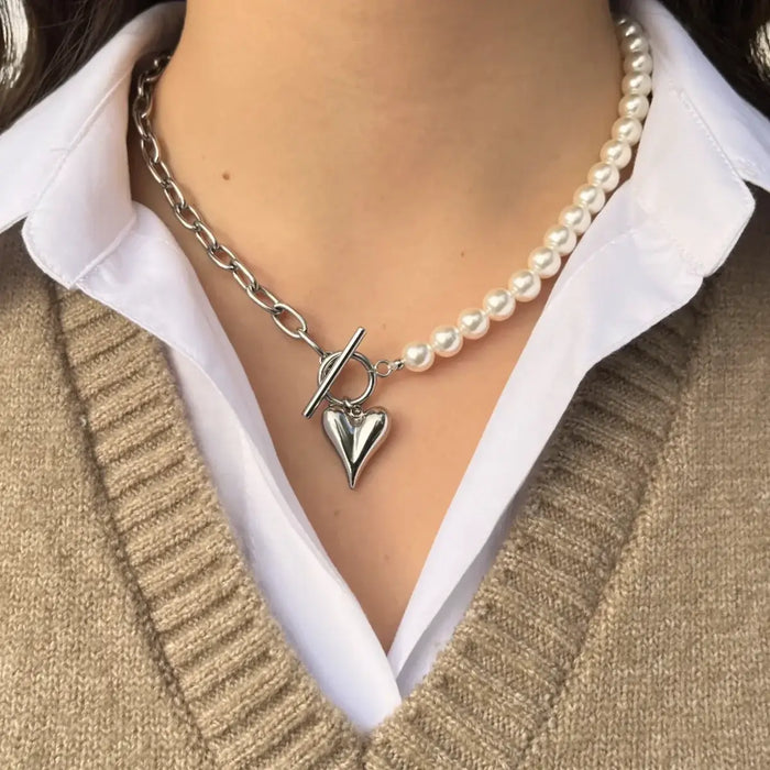 Collier Prague en acier inoxydable argenté porté, combinaison de perles et chaîne moderne, orné d'un charm cœur pour un style à la fois romantique et élégant.
